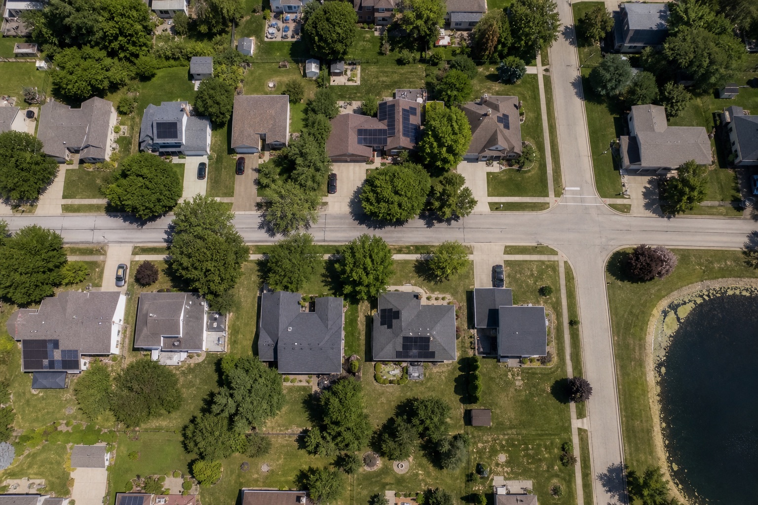 Straight-down drone view of rooftop solar on several homes in an Illinois subdivision