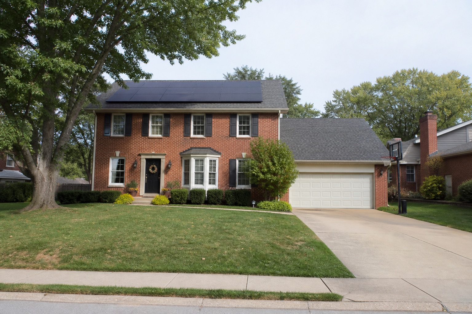 Two-story brick home with black shutters and rooftop solar panels